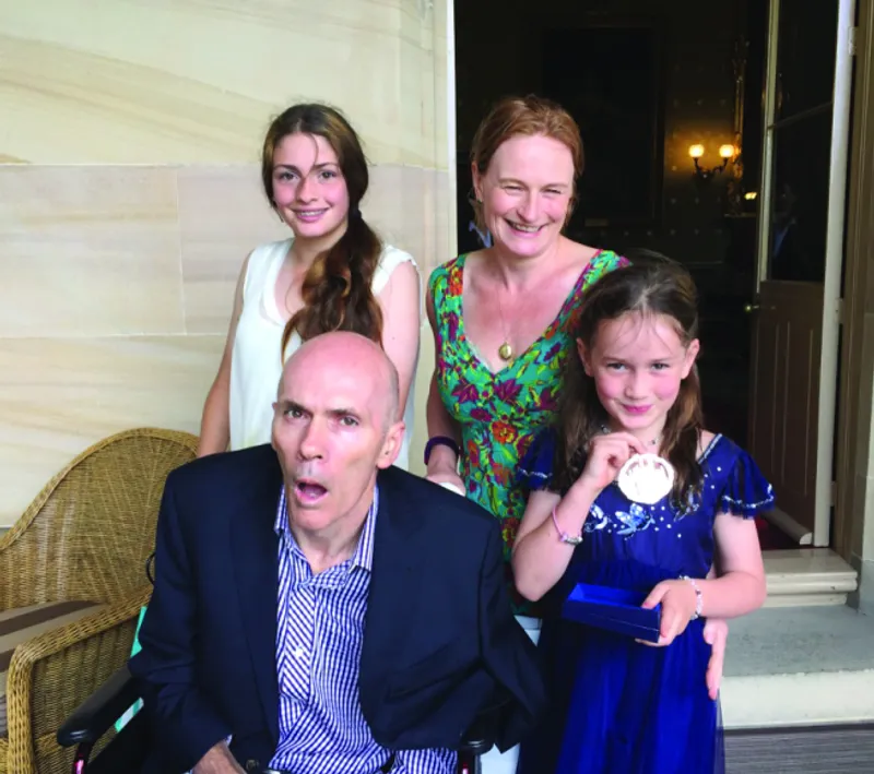 Lisa, Bob and their 2 happy daughters. Bob is in a wheelchair and visibly ill